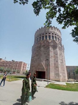 Unos soldados armenios pasan al lado de una de las iglesia modernas de Echmiadzín